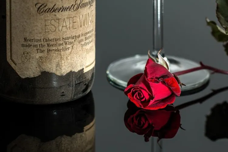 bottle of Cabernet wine with a rose in front of the bottle